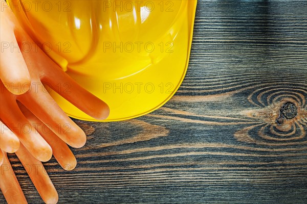 Hard hat electricians gloves on wooden board