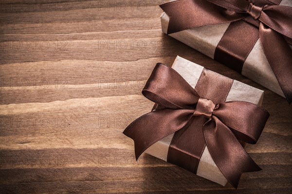 Present containers with brown ribbons on vintage wooden board