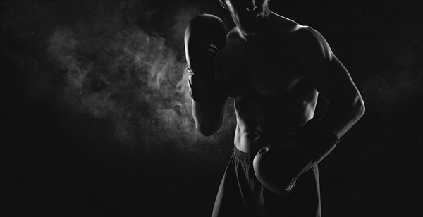 Noname image of a kickboxer on a dark background. The concept of mixed martial arts. MMA