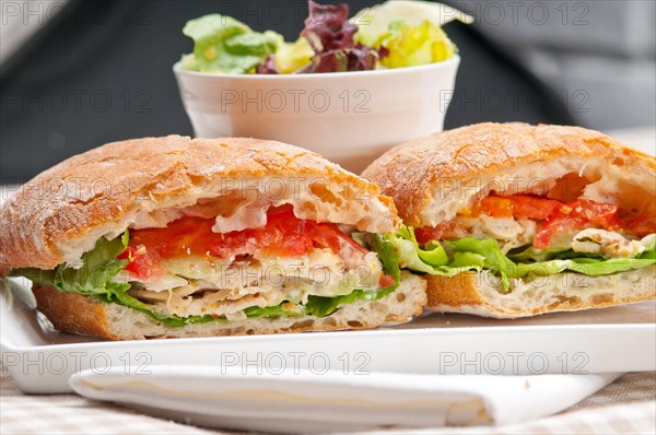 Italian ciabatta panini sandwich with chicken and tomato