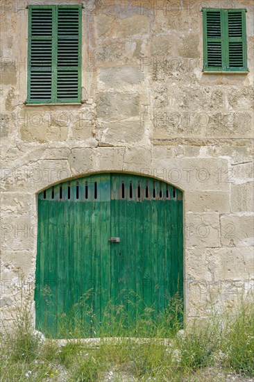 Facade of an old farm. Door and windows of natural wood texture