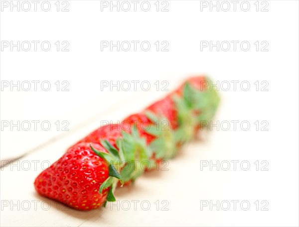 Fresh organic strawberry over white rustic wood table