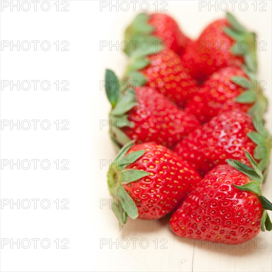 Fresh organic strawberry over white rustic wood table