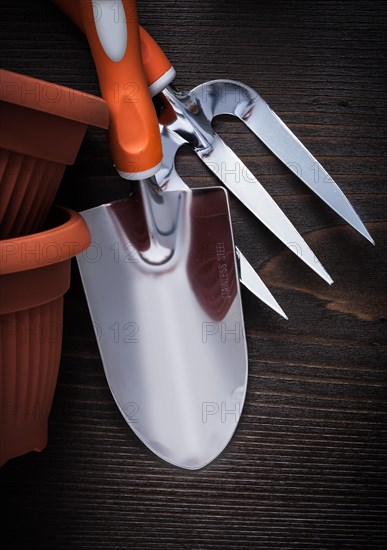 Clay planting pots trowel fork and hand spade on vintage wood board close up image gardening concept
