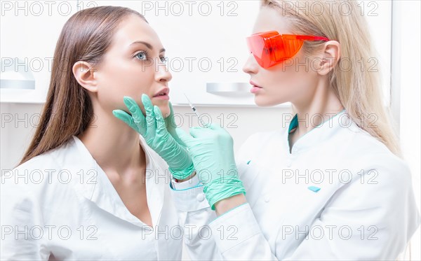 Portrait of two girls in white coats. The concept of cosmetology