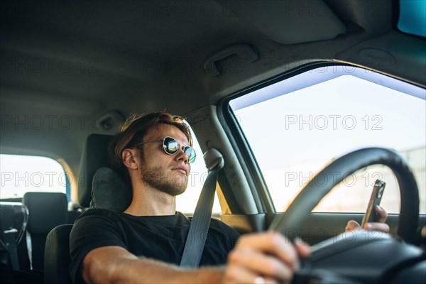 Young handsome male driver tired of sitting behind the wheel