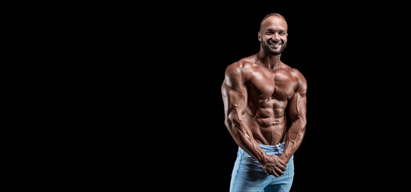 Isolated muscular man on a black background. Bodybuilding and fitness concept. Panorama.