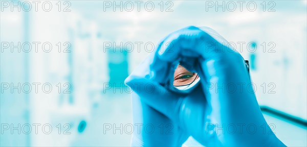 Portrait of a doctor in a medical center. He is looking through his hands. Medicine concept.