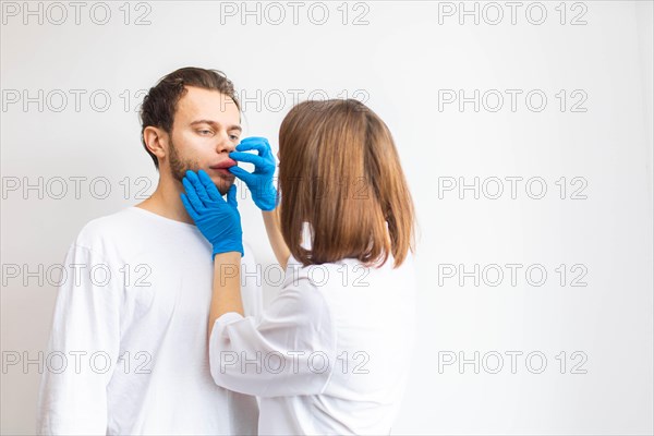 Doctor examines allergic swelling on the patient's lip