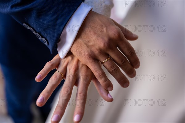 Hands of bride and groom embraced with rings at a beautiful wedding