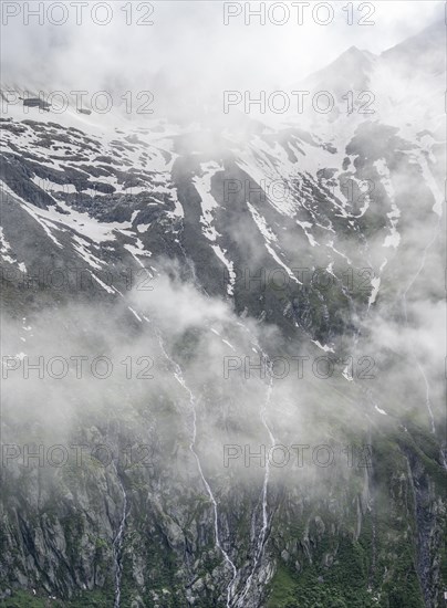 Snow-covered cloudy mountains, mountain streams as waterfalls on a mountain slope, Furtschaglhaus, Berliner Hoehenweg, Zillertal, Tyrol, Austria, Europe