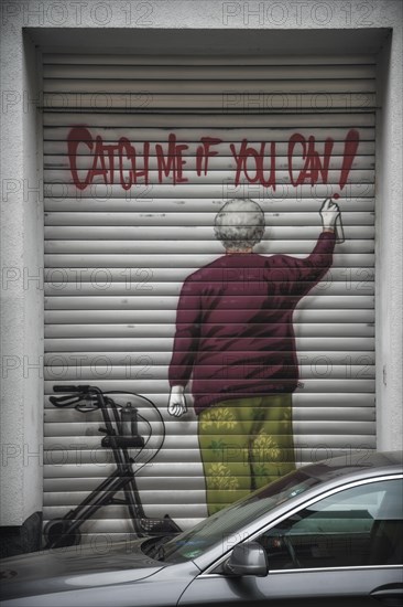 Garage door with graffiti of a man spraying 'Catch me if you can', Wuppertal Elberfeld, North Rhine-Westphalia, Germany, Europe