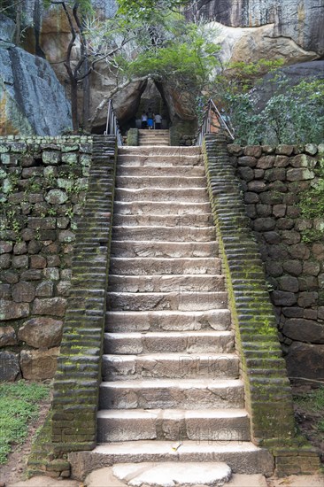 People climbing steps of stone staircase to the rock palace at Sigiriya, Central Province, Sri Lanka, Asia