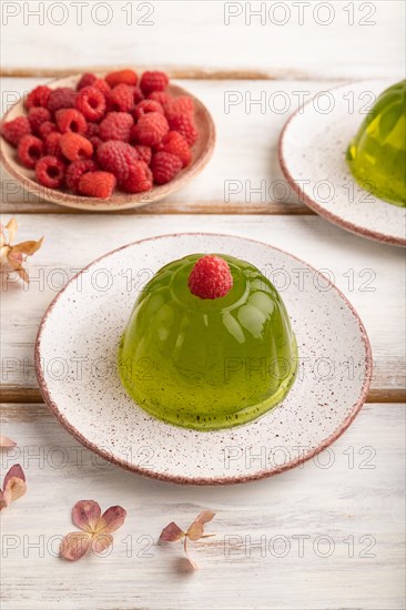 Mint and raspberry green jelly on white wooden background. side view, close up