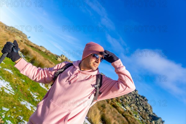 Portrait of a man on the top of the mountain when trekking, looking at the sunrise