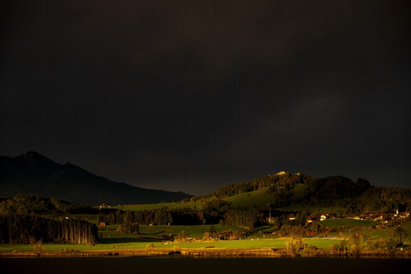 Lake Hopfensee with stormy sky in soft morning light and Allgaeu mountains in the background, Hopfen am See, Ostallgaeu, Swabia, Bavaria, Germany, Europe