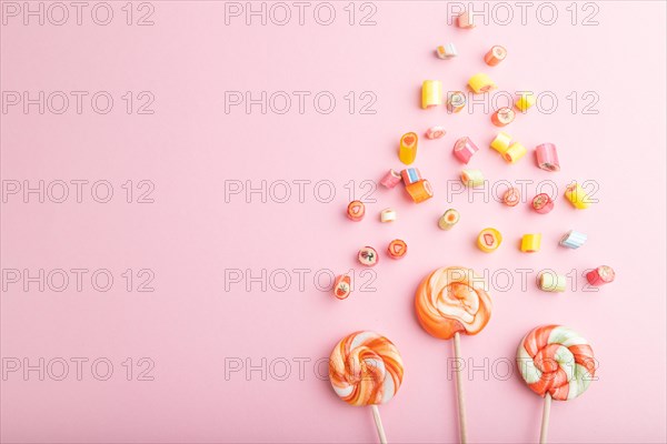 Various caramel candies on pink pastel background. copy space, top view, flat lay