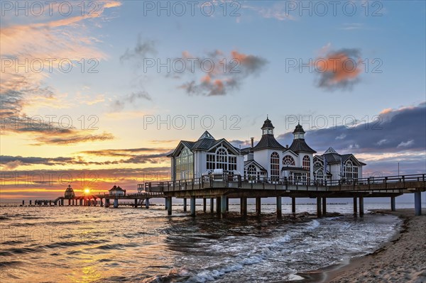 Sunrise on the pier in Sellin with glowing clouds