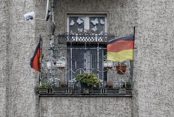 A German flag with a federal eagle flutters on the balcony of a run-down apartment building, Berlin, 22/01/2020