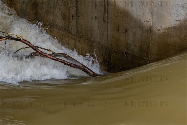 Tree branch held next to dam's support column by surging water through floodgate in Daejeon South Korea