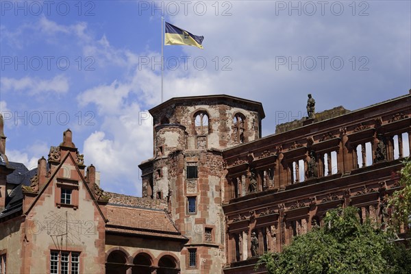 Part of a castle (Heidelberg Castle), with a waving flag on the tower against a cloudy sky, Heidelberg, Baden-Wuerttemberg, Germany, Europe