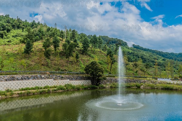 Water fountain in small man made pond under blue cloudy sky in South Korea