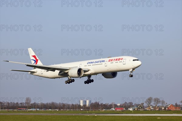 China Eastern Airlines Boeing 777-39P (ER) with registration B-2023 approaching the Polderbaan, Amsterdam Schiphol Airport in Vijfhuizen, municipality of Haarlemmermeer, Noord-Holland, Netherlands