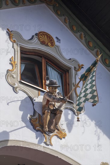 Wooden figure of a boy in lederhosen with Bavarian diamond flag white-blue at the Fraundorfer Inn, Ludwigstrasse, Partenkirchen district, Garmisch-Partenkirchen, Werdenfelser Land, Upper Bavaria, Bavaria, Germany, Europe