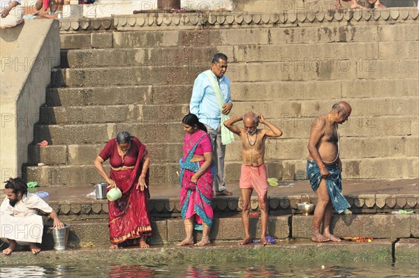 People performing ritual ablutions on a river bank in the early morning, Varanasi, Uttar Pradesh, India, Asia