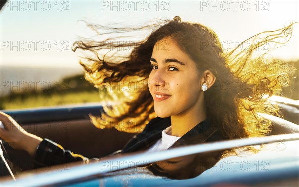 Young woman driving open-top in blue convertible with blowing hair, AI generated, AI generated