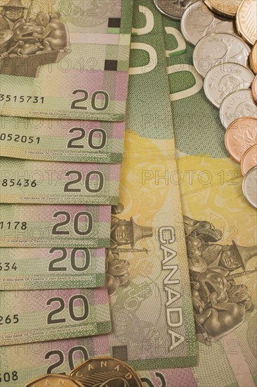 Close-up of reverse side of green, yellow and pink Canadian Bank of Canada twenty dollar bills with assorted coins, Studio Composition, Quebec, Canada, North America