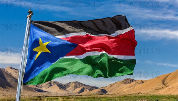 The flag of South Sudan, fluttering in the wind, isolated, against the blue sky