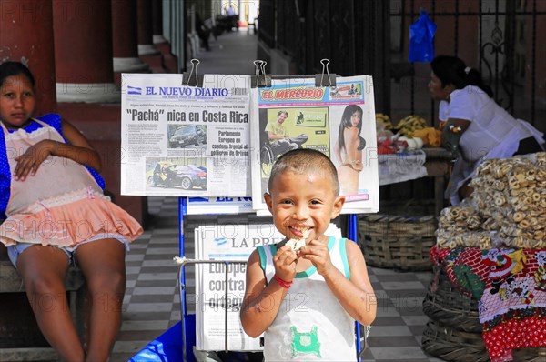 Granada, Nicaragua, Happy child presents newspaper headlines while selling on the street, Central America, Central America -, Central America
