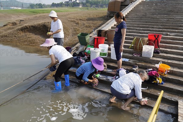 Women washing clothes in the Yangtze River, Yichang, Hubel Province, China, Several woman washing clothes on the riverbank, surrounded by rural landscape, Yangtze River, Chongqing, Chongqing Province, China, Asia