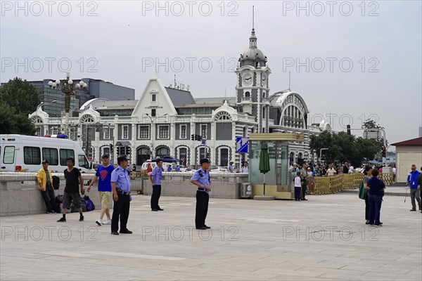 Beijing, China, Asia, City square with people walking and a historical building with clock tower in the background, Asia