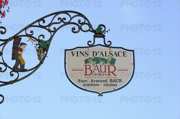 Eguisheim, Alsace, France, Europe, A metal wine sign with the inscription 'VINS D'ALSACE BAUR' in front of a blue sky, Europe