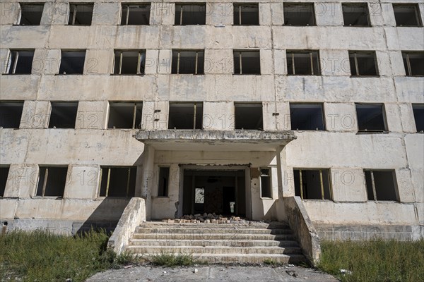 Entrance to an abandoned ruined residential building, old Soviet apartment block in the ghost town, Engilchek, Tian Shan, Kyrgyzstan, Asia