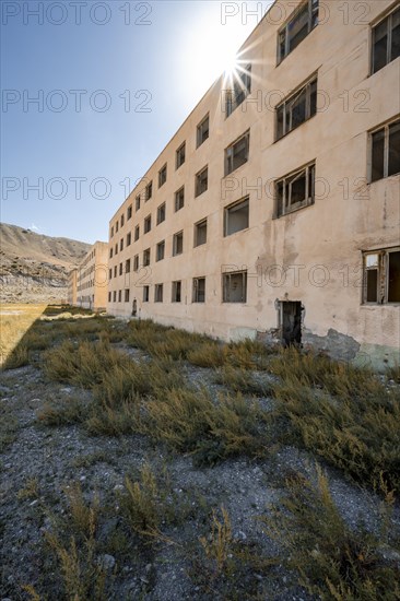 Abandoned destroyed residential building, Sun Star, old Soviet apartment block in the ghost town, Engilchek, Tian Shan, Kyrgyzstan, Asia