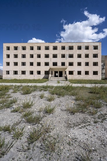 Abandoned destroyed residential building, old Soviet block of flats in the ghost town, Engilchek, Tian Shan, Kyrgyzstan, Asia