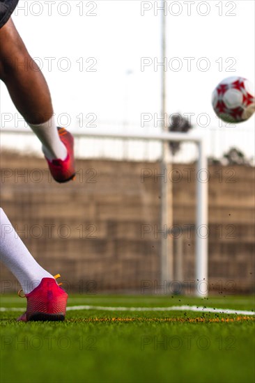 Football player feet running with the ball in front of the field. Player feet with the ball scoring a goal. Football player on the field running with the ball