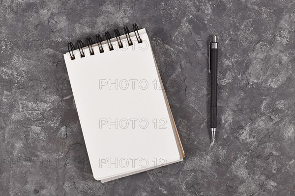 Empty notebook with white paper next to pen