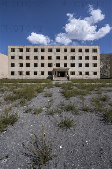 Abandoned destroyed residential building, old Soviet block of flats in the ghost town, Engilchek, Tian Shan, Kyrgyzstan, Asia