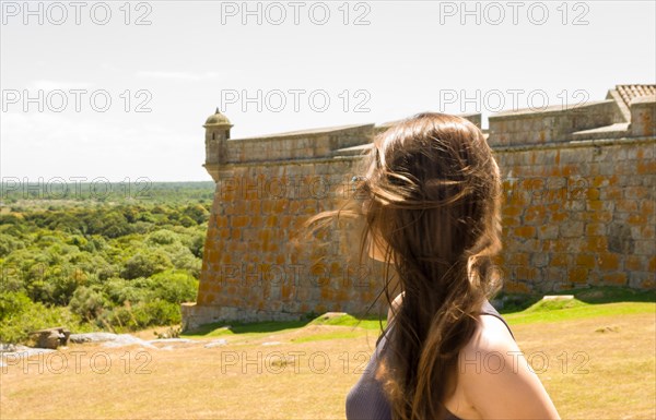 Young woman looking at Forte de Santa Tereza in Uruguay, important tourist site