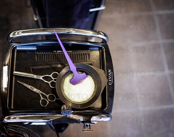 Tray of a hairdresser with mixed hair colour, scissors and comb, taken in the hairdressing salon Coiffeur Sivan in Berlin, 22.04.2024