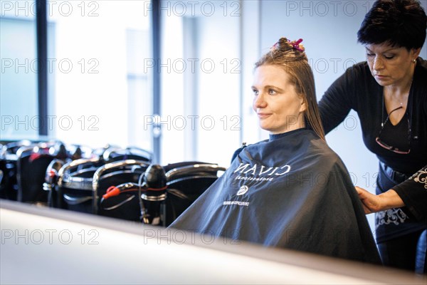 Valentyna Vysotska, hairdresser from Ukraine, bleaks her customer's hair, taken at the hairdressing salon Coiffeur Sivan in Berlin, 22/04/2024