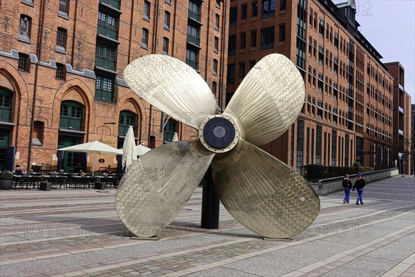 International Maritime Museum, Koreastrasse, Hafencity, Hamburg, A large ship's propeller in front of historic brick buildings on an urban promenade, Hamburg, Hanseatic City of Hamburg, Germany, Europe