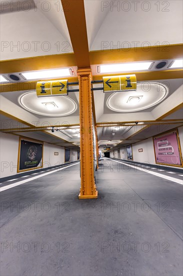 Underground station with artistic yellow columns and advertising posters on the walls, Berlin, Germany, Europe