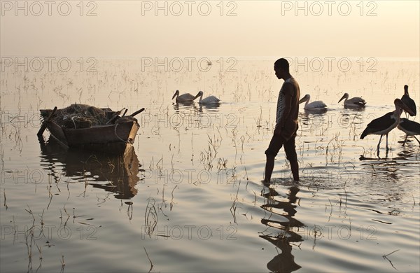 Fisherman walking to his boat before going to fish. Lake Ziway, Oromiya state, Ethiopia, Africa