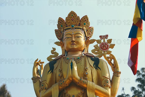 Ornate golden Avalokitesvara female Buddha statue against a clear blue sky background in Swayambhu Buddha Park Ring Road which is a popular tourist destination in Kathmandu, Nepal, Asia