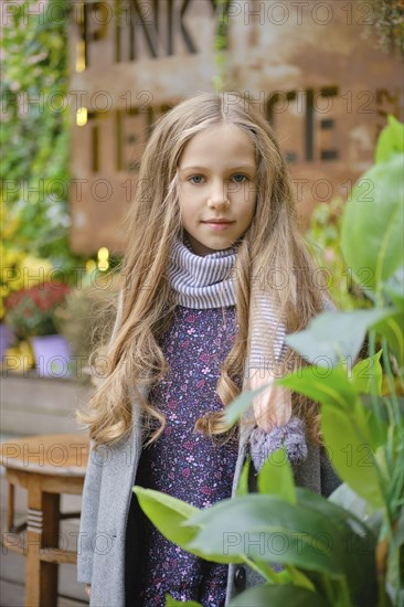 Outdoor portrait of pretty little girl with long curly hair